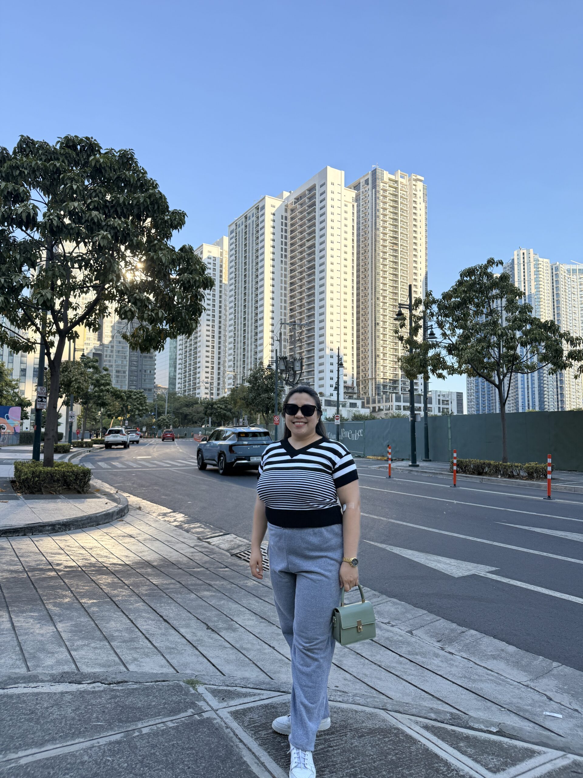 Arianne of ajcpreligera posting behind her are skysrappers in Bonifacio Global City